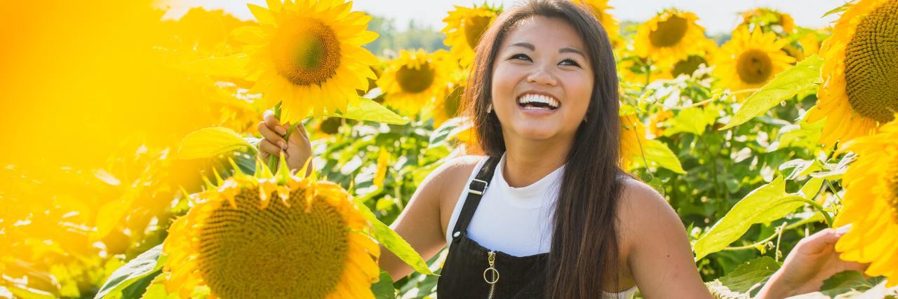photo of smiling or laughing woman in a field of sunflowers