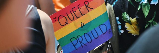 A sign that says Queer and Proud