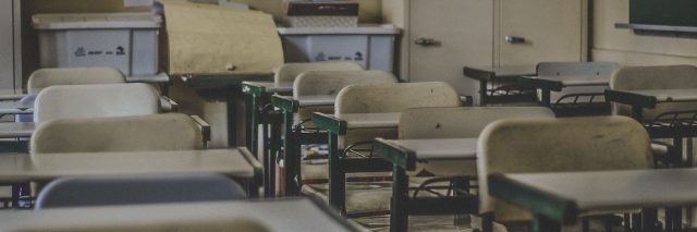 Empty school classroom showing rows of desks