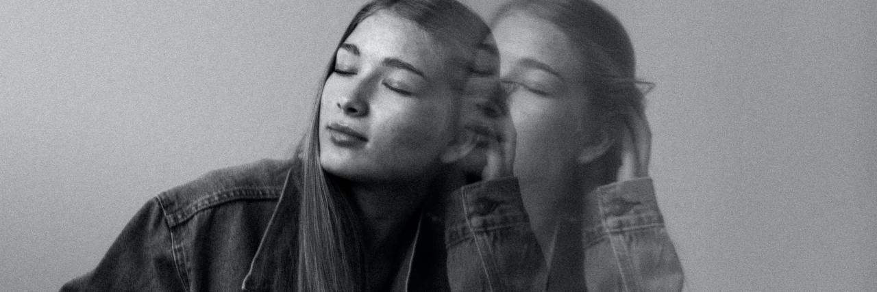 Can You Be 'High Functioning' With 'Severe' Depression? black and white photo of woman in double exposure, sitting on floor with her eyes closed