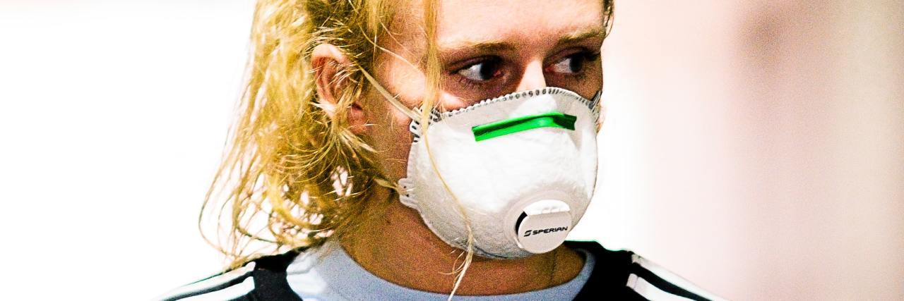 Feeling Guilty for Being Suicidal During the COVID-19 Pandemic photo of woman wearing a coronavirus mask and looking off to the side, upset