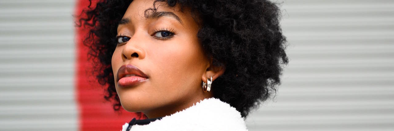 3 Types of 'Self-Care' Boundaries You Should Be Setting a woman standing in front of a red arrow on a wall