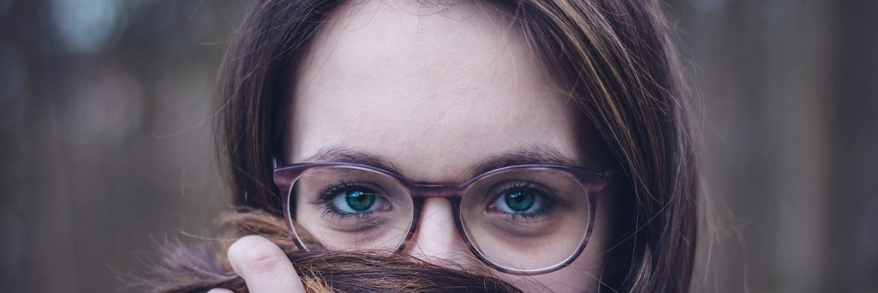 My Anxiety Is Not up for Discussion Woman smiling and wrapping her hair over her face