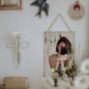 photo of woman taking a photo of herself from a reflection in a mirror, which rests near some white flowers