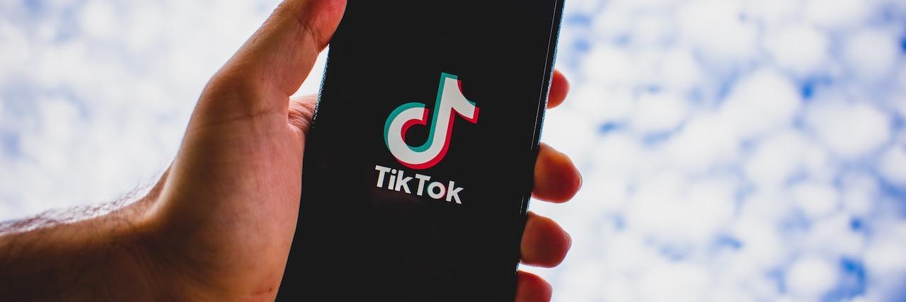 People Use Coded Phrases on TikTok to Share Suicidal Thoughts Hand holding a phone showing the TikTop app