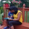 Tulika and her son using a tablet on the patio outside.