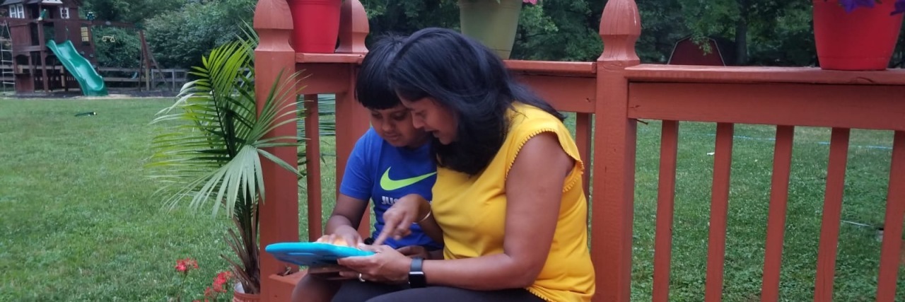 What the Lockdown Can Teach Us About Making Education More Inclusive Tulika and her son using a tablet on the patio outside.