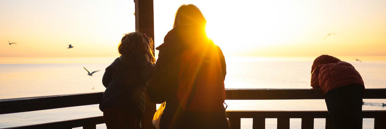 Realizing the World Keeps Turning Despite Uncertain Times Silhouette of woman and two children