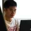 young asian man with laptop looking worried