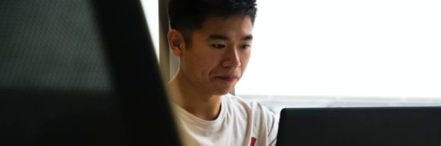 young asian man with laptop looking worried
