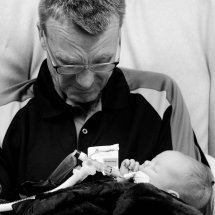 A grandfather holding a new baby