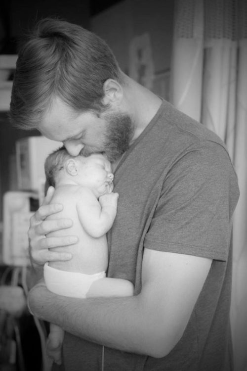 A new baby being cradled on his dad's chest