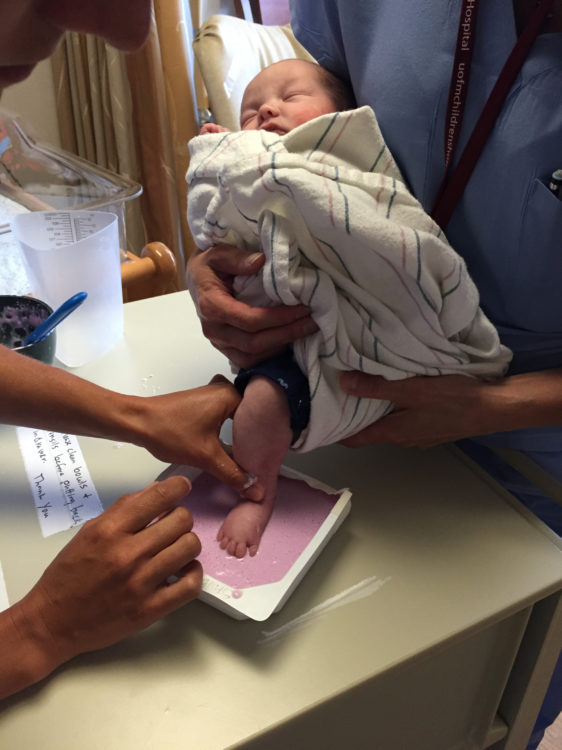 A baby is having feet impressions taken at the hospital