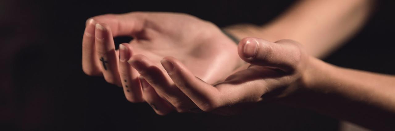 Why I Say I’m 'Recovered' Even Though I Still Self-Harm hands being held out