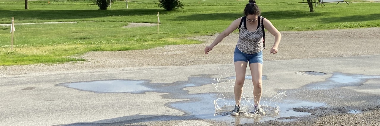 photo of contributor jumping in a puddle, looking down at the water