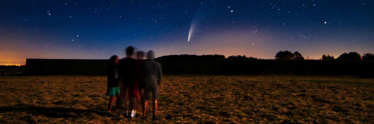 Why I'm Thankful I'm Still Here After Wanting To Die photo of group of people standing in a field looking at comet neowise in the distance just over the horizon