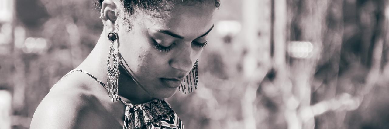 The Emotions Black People Are Experiencing During Black Lives Matter black and white photo of Black woman looking down in sadness