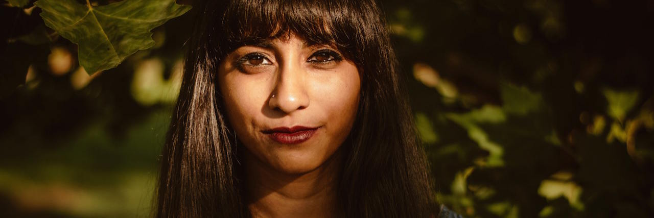 What Happens When You Call Out Racism as a BIPOC A young woman standing outside, with a serious expression