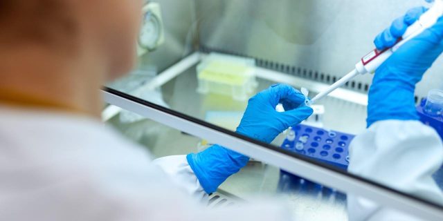 The Industry Response to COVID-19 Is a Blueprint for Accelerating Rare Disease Treatments A scientist injecting something into a test tube