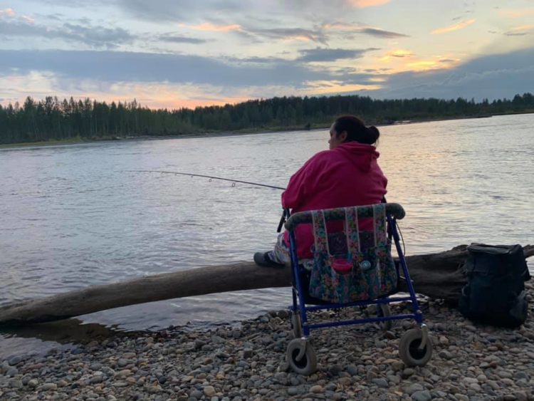 A woman sitting in a camper while fishing