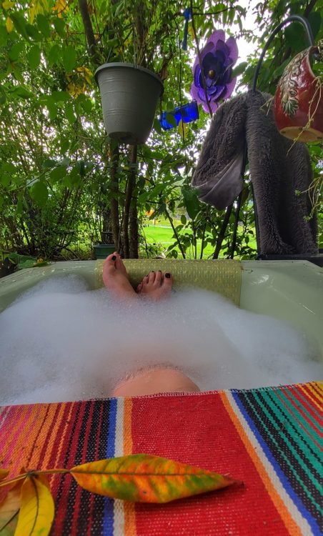 A woman soaking in a tub outside