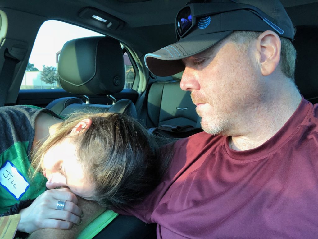 photo of the contributor and her partner, as she lies her head on his arm in a car