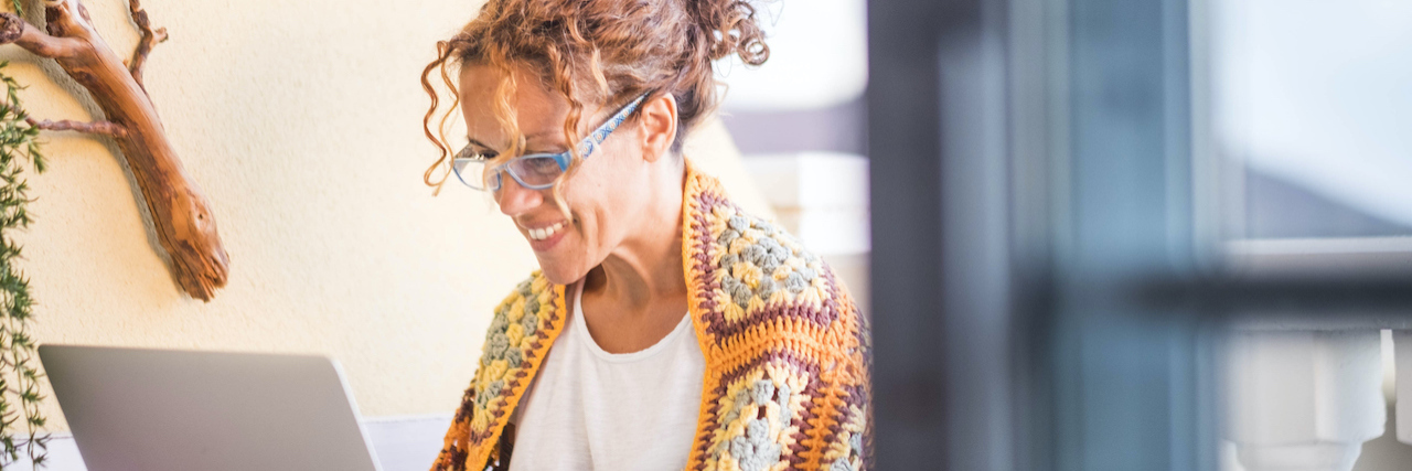 What Google Said When I Asked Why Bipolar Makes Me Feel Helpless woman smiling and working on a laptop