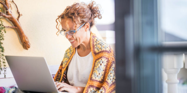 What Google Said When I Asked Why Bipolar Makes Me Feel Helpless woman smiling and working on a laptop