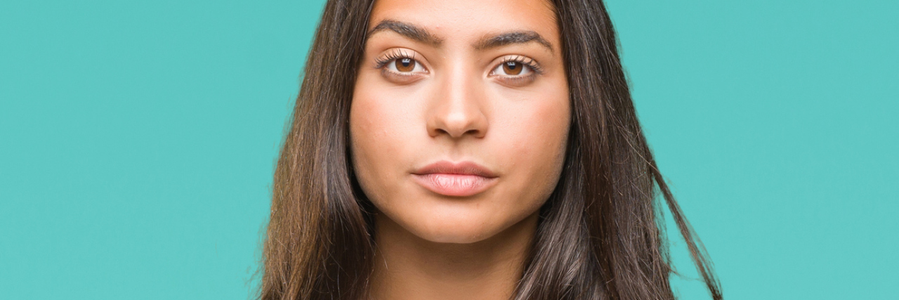 Minorities Don't Feel They Can Be Completely Honest in Therapy photo of womana gainst isolated background looking into camera with a serious expression