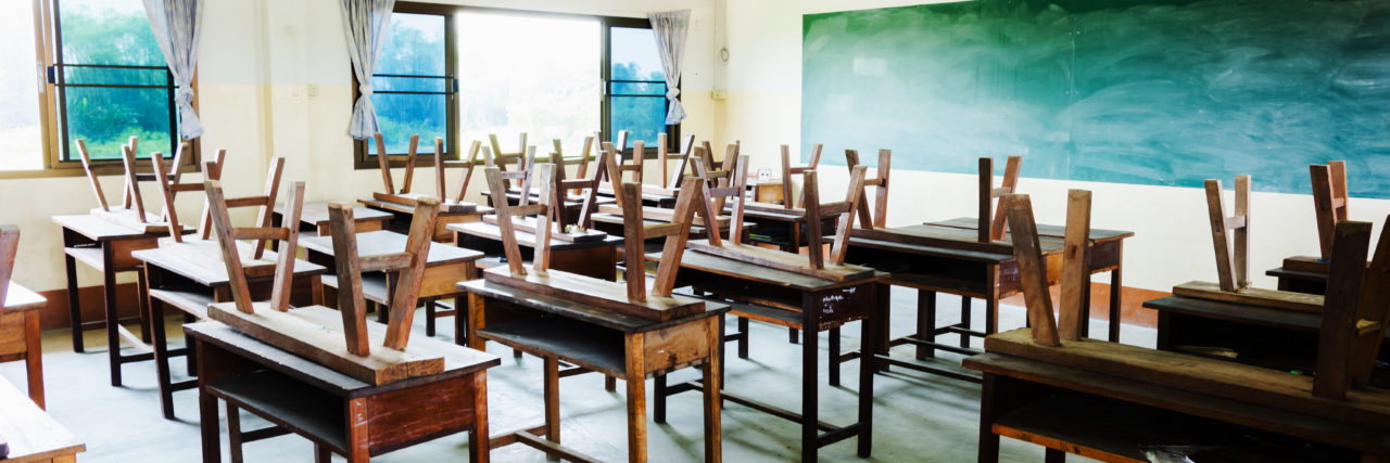 How COVID-19 Is Affecting UK Students With Disabilities chair and table in classroom with chalkboard.