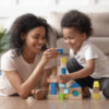 Black mother and son build blocks on the ground