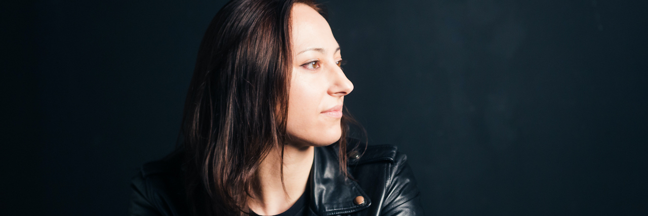 A woman in a leather jacket looking to the side