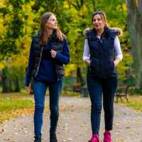 Two women walking in city park