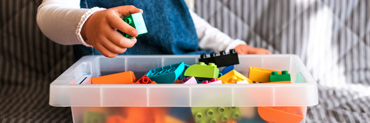 5 Things You Should Know About Acid Sphingomyelinase Deficiency  Little girl cleaning up the toy box at home.