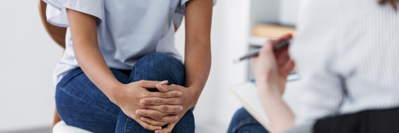 Why Mental Health Counseling Is Important for Reproductive Cancers two people sitting across from each other in a therapy session, focus on lower halves of body