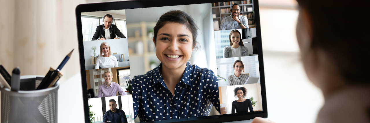 Woman at desk looking at computer screen with a collage of diverse people