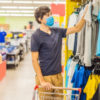Man in a clothing store in a medical mask because of a coronavirus.