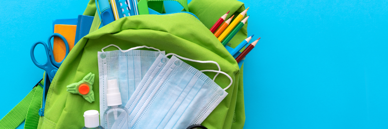 What School Choice Means for Kids With Disabilities During COVID-19 Backpack with school supplies and set of sanitizers and medical protective masks.