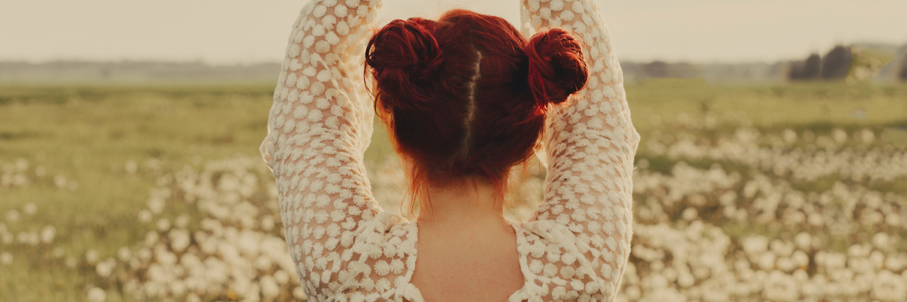 Chronic Illness: Stop Complimenting People for Losing Weight A woman in a field of white flowers, with her hands above her head
