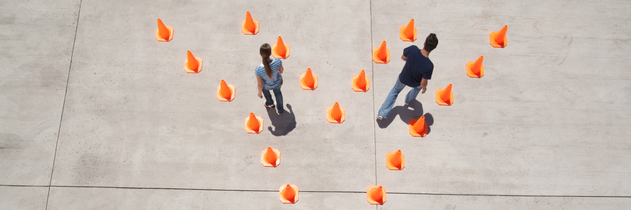 Man and woman in traffic cones moving apart