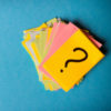 A pile of post-it notes with a question mark on the top one