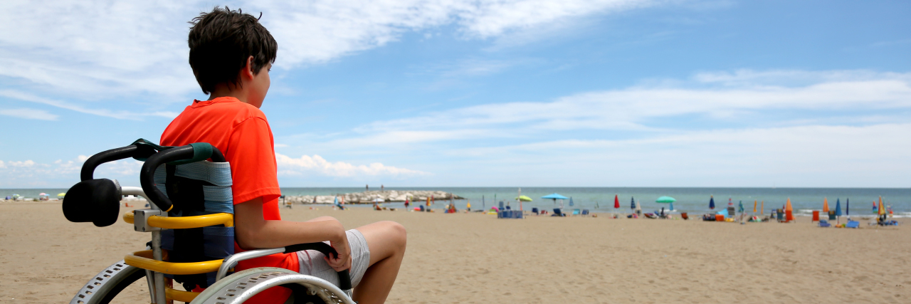 Why I Spread Awareness About Spinal Muscular Atrophy Boy using a beach wheelchair