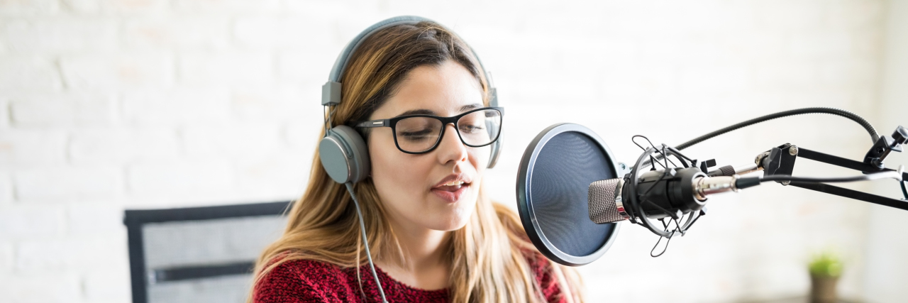 Young woman recording a podcast.