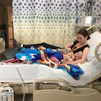 a mom sitting with her toddler in a hospital bed