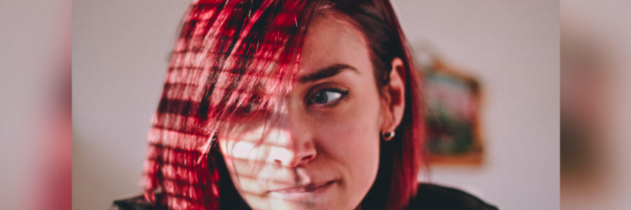 The Balancing Act of Having Multiple Mental Illnesses Woman with red hair biting her lip