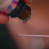 Personal drips essential oil onto a paper strip