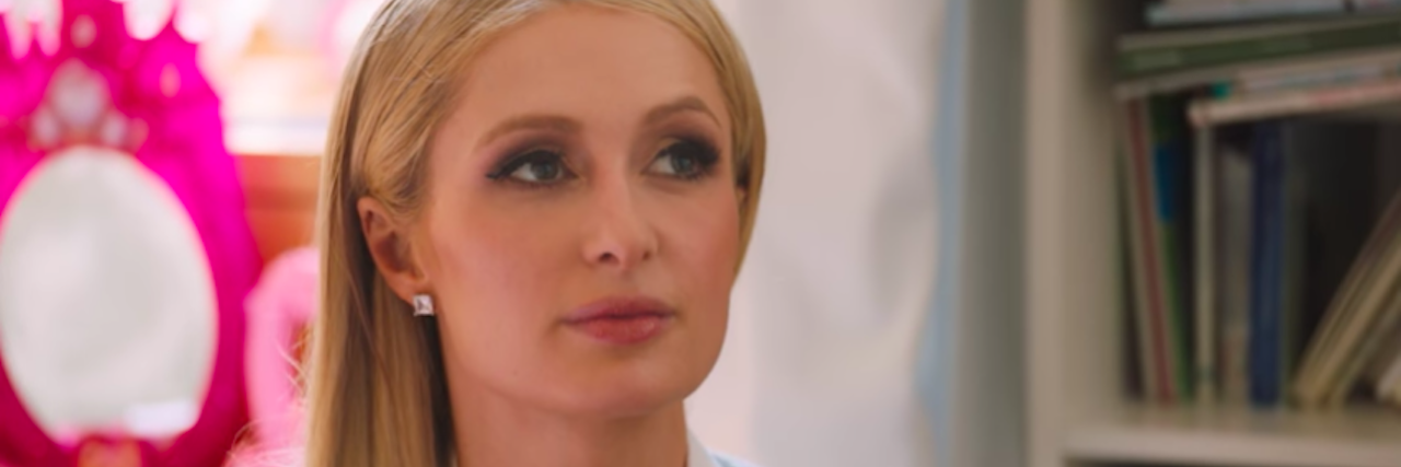 Paris Hilton Shares Impact of Trauma in New Doc ‘This Is Paris’ Paris Hilton, wearing a white collared shirt, gray sweater and her long blonde hair pushed in front of one shoulder