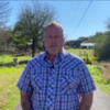 Rob Anderson, an older man wearing a short-sleeve plaid shirt standing on a country Louisiana road