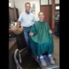 A young man is sitting in his barber's chair