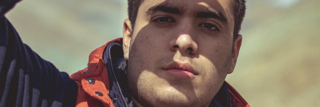 What People Did Before They Realized They Were Autistic A man holding his hands to block the sun